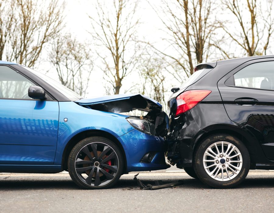 Two cars involved in traffic accident on side of the road with damage to bonnet and fender