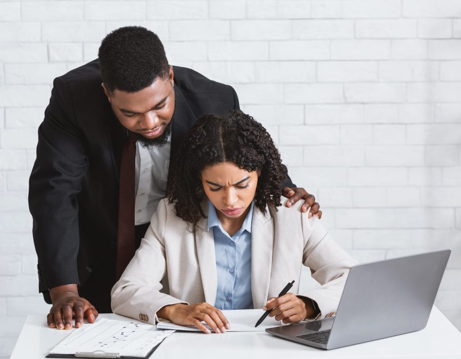 Stop sexual harassment concept. Perverted African American boss touching his attractive female assistant at office